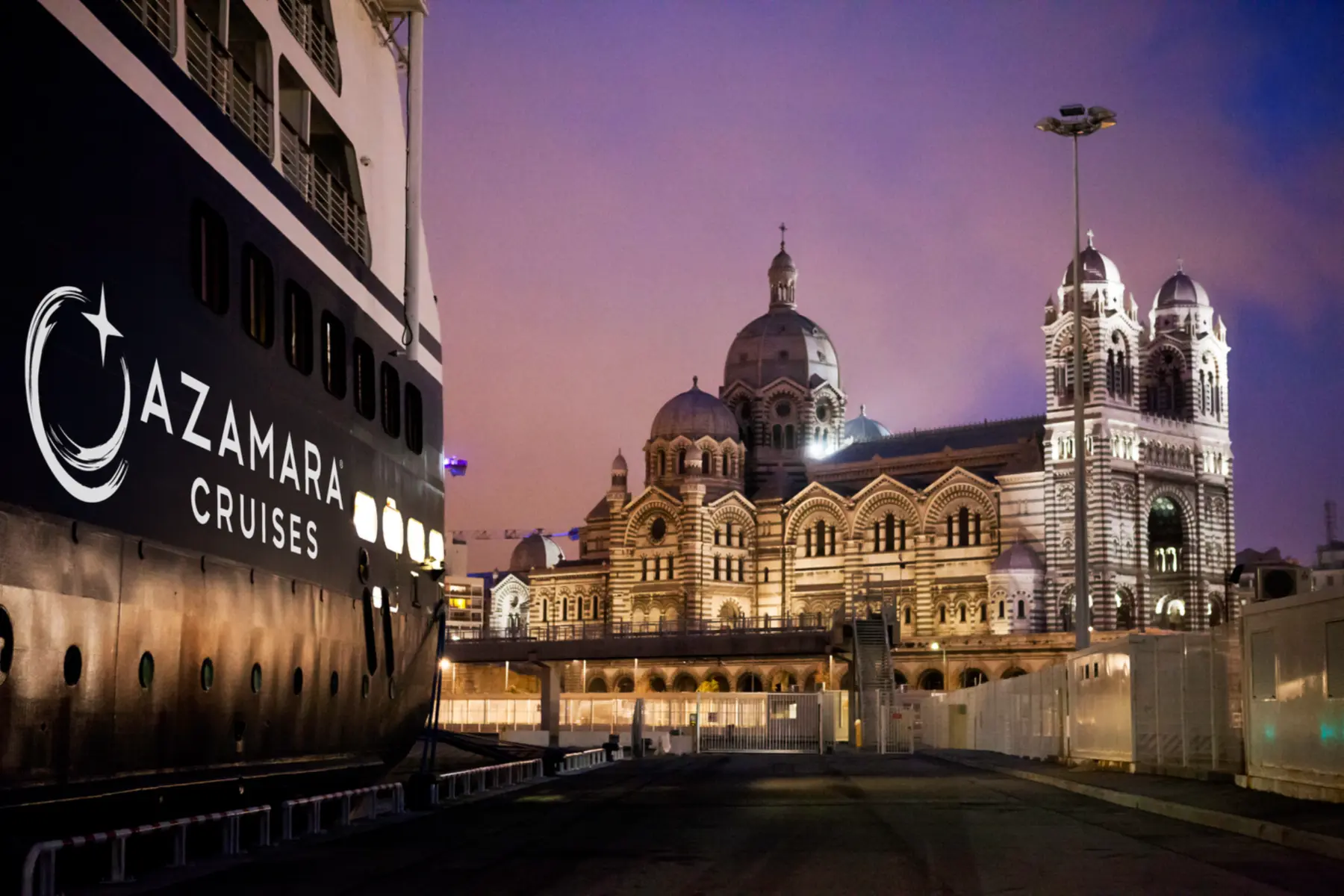 Azamara cruise ship docked beside Marseille Cathedral at twilight