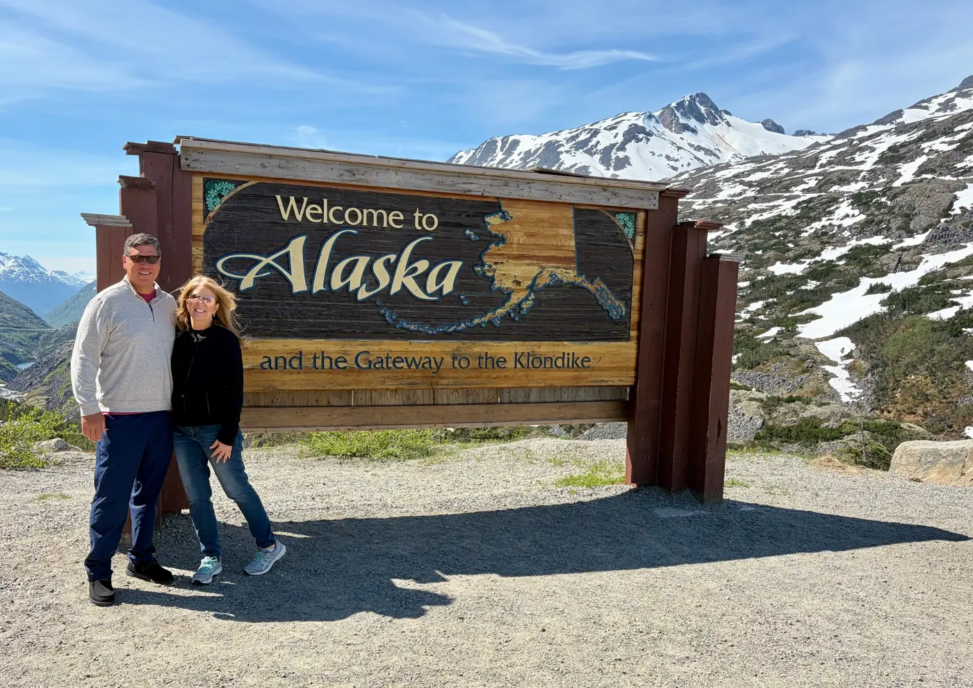 Melissa and companion at a Welcome to Alaska sign on the Klondike Highway