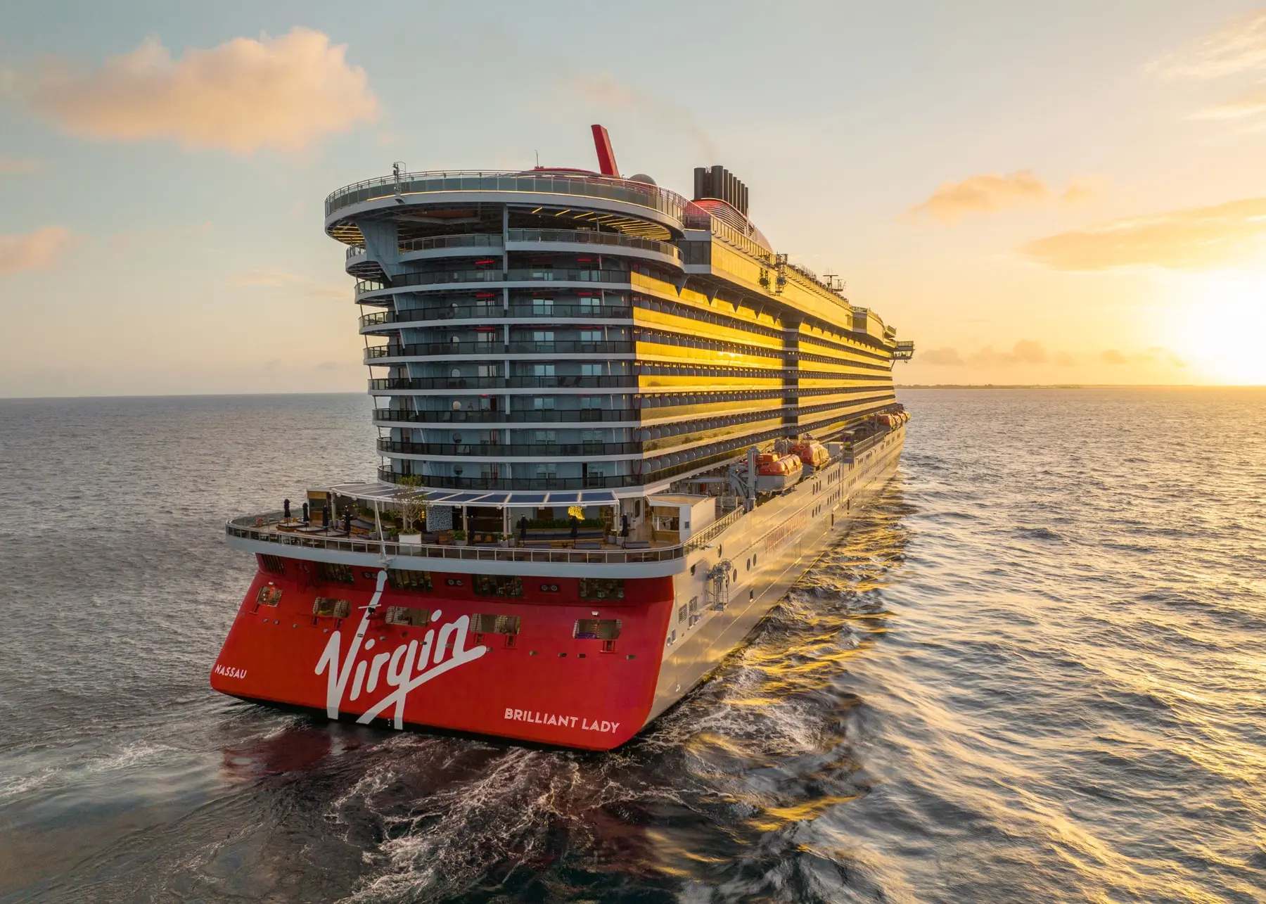 Virgin Voyages Brilliant Lady sailing at sunset