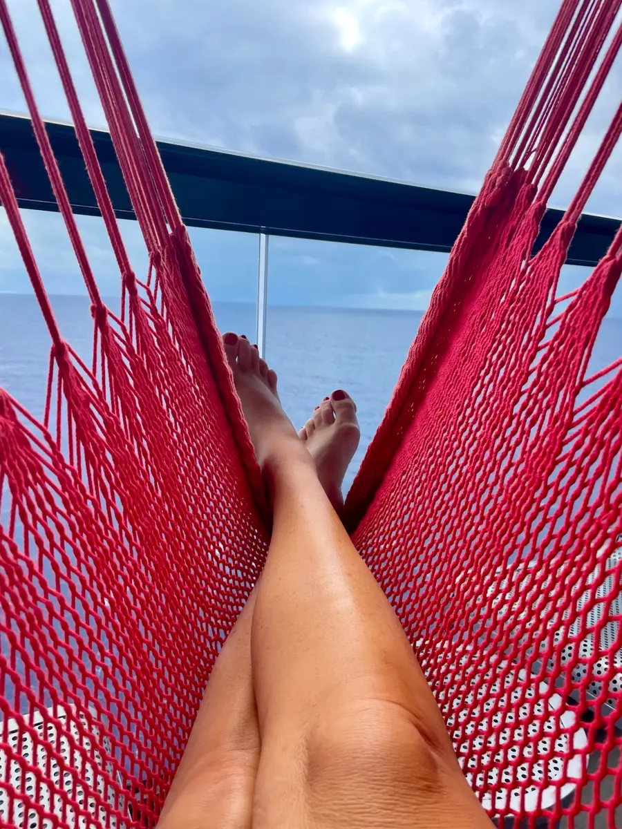Relaxing in a red hammock on a Virgin Voyages Sea Terrace