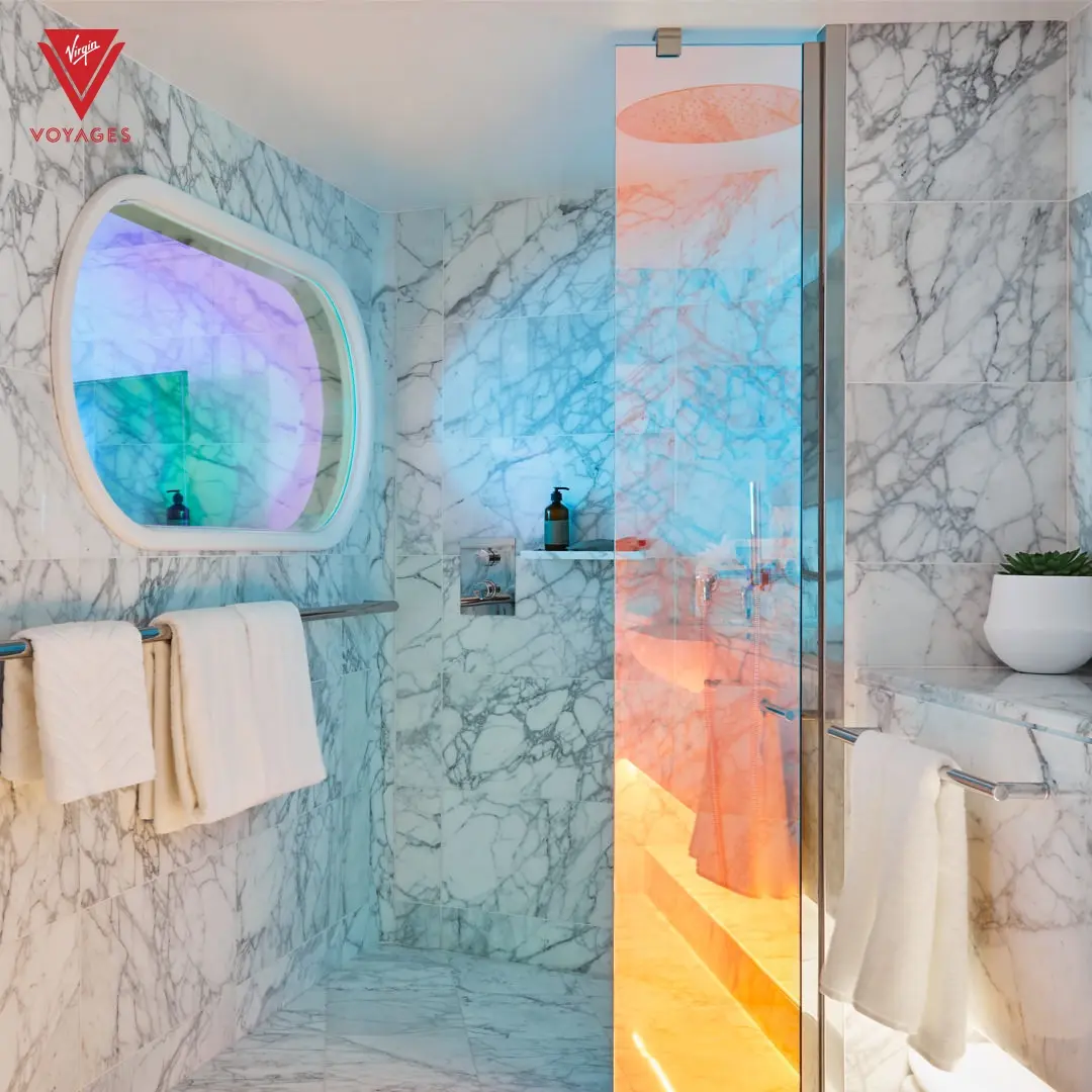 Marble bathroom and glass shower in a Virgin Voyages RockStar Quarter